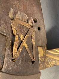 A Japanese gilt-lacquered 'kura' saddle with matching 'abumi' stirrups, Muromachi, 16th C.